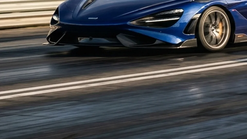 Mid-engine supercar launching hard off starting line with tire smoke and weight transfer
